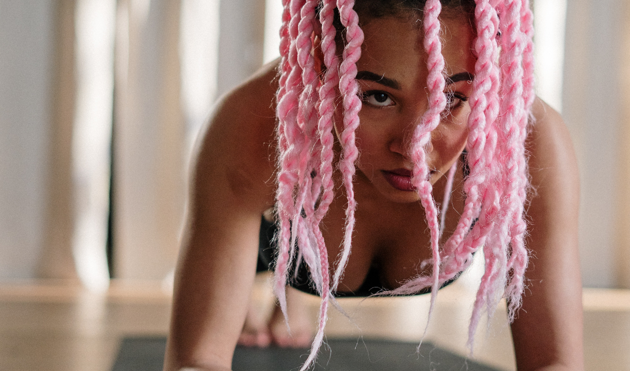 sporten in de ochtend - meisje met roze haren op gymmat